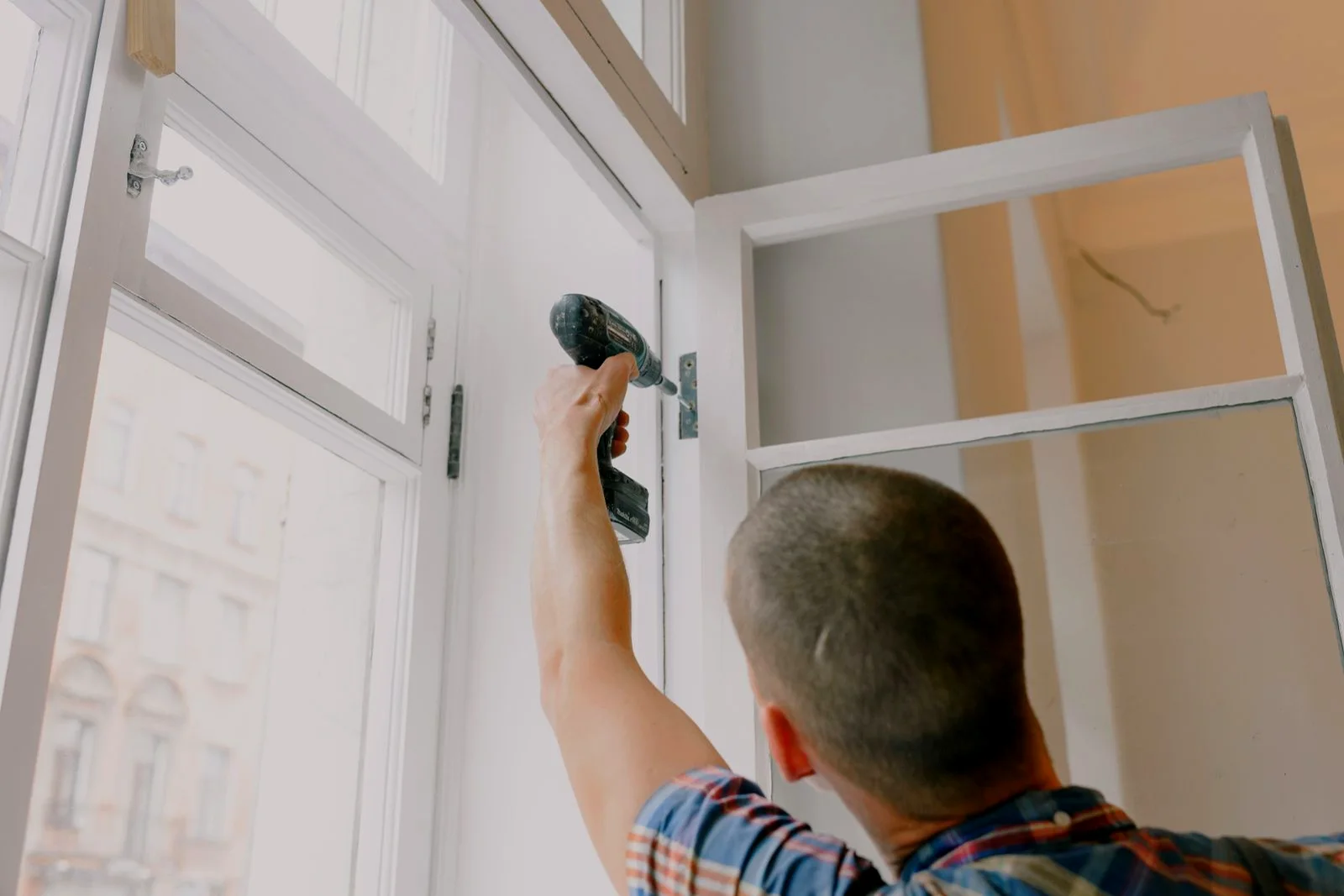 Maintenance technician installing a commercial door and frame during facility maintenance work